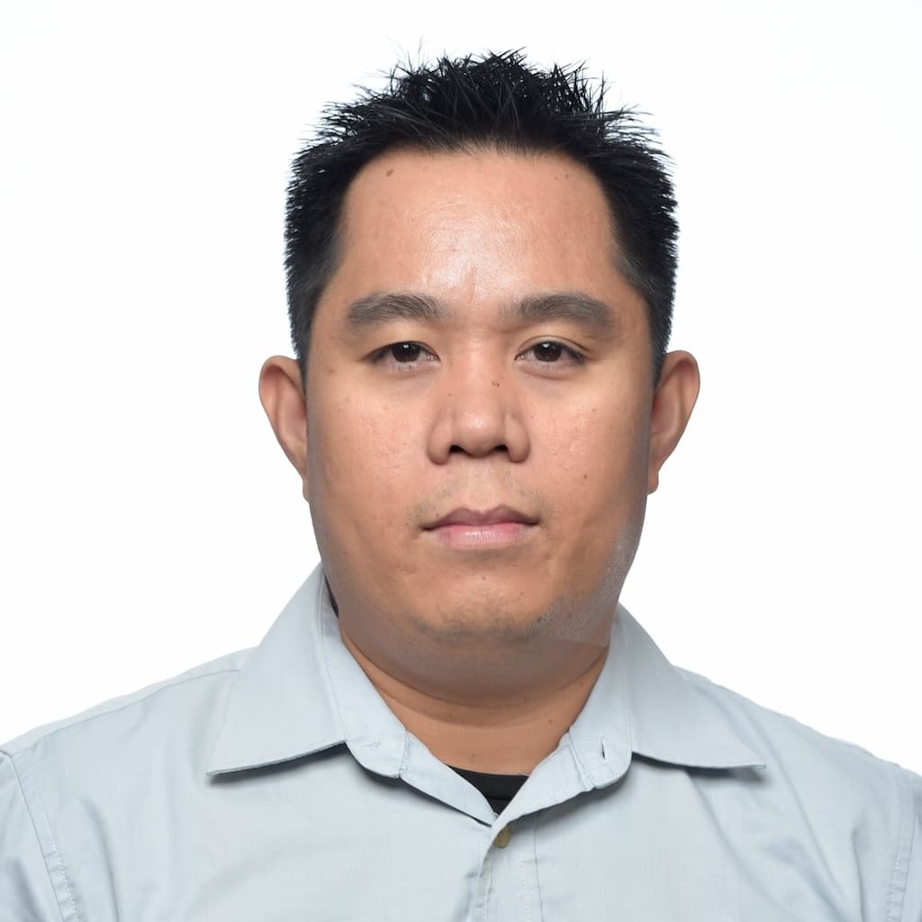 Romualdo Dasig, facing the camera in a pale blue collared shirt.